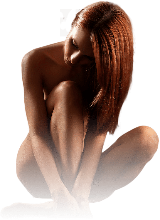 Naked red hair woman sitting with her legs and arms covering her private parts